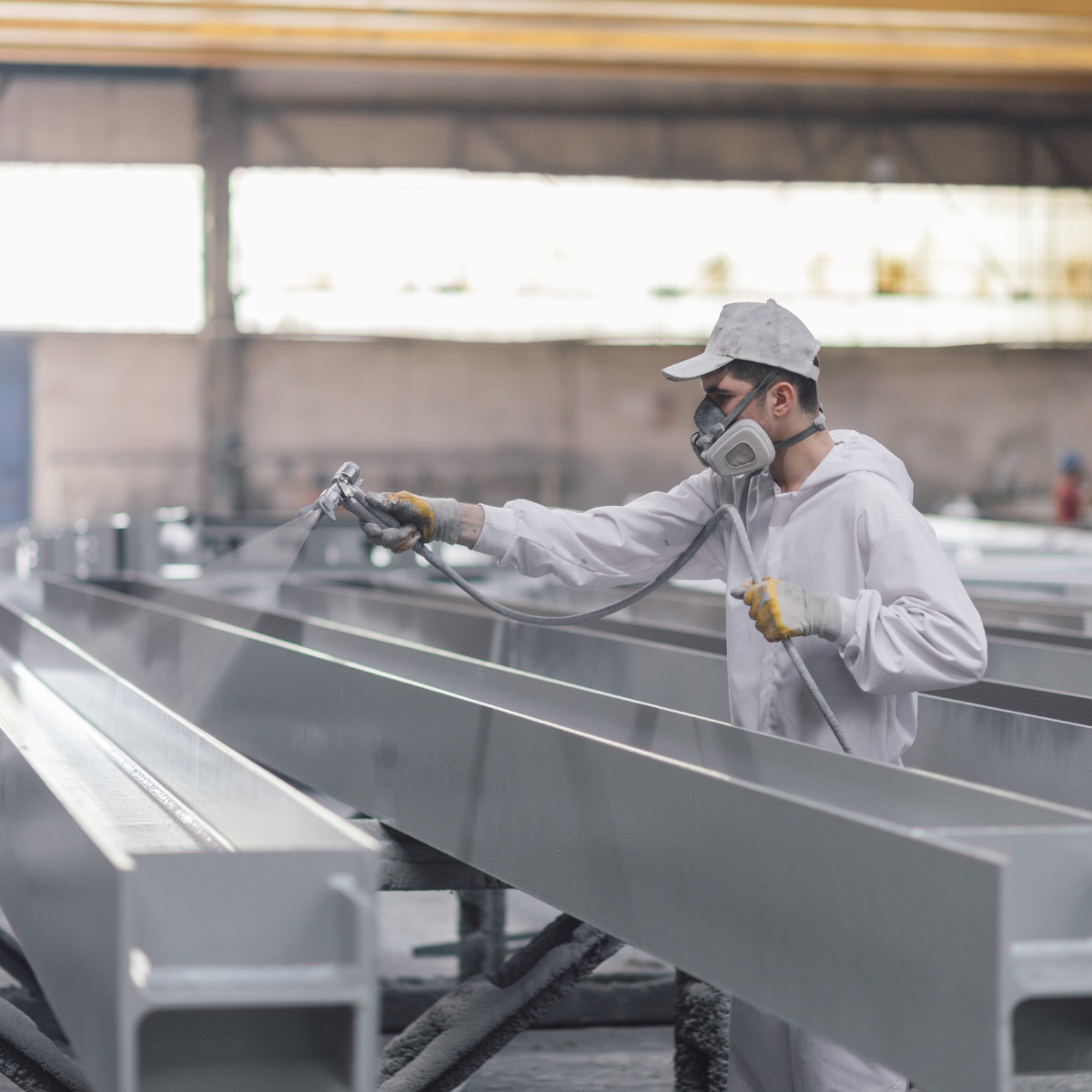 Manufacturing worker powder coating a large sheet metal part